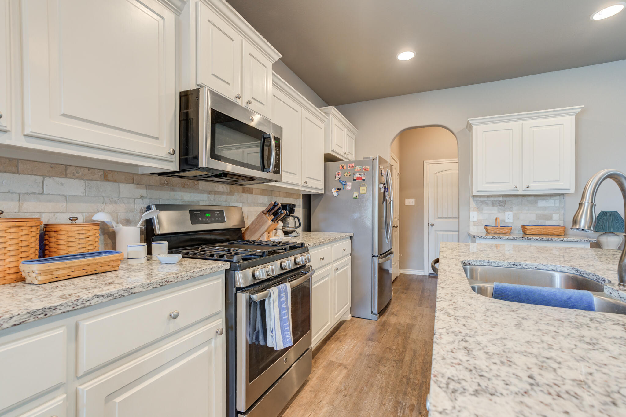 5219 Kemper Street Lubbock, TX 79416 - Photo 18 of 38 a kitchen with stainless steel appliances granite countertop a stove a sink and a microwave