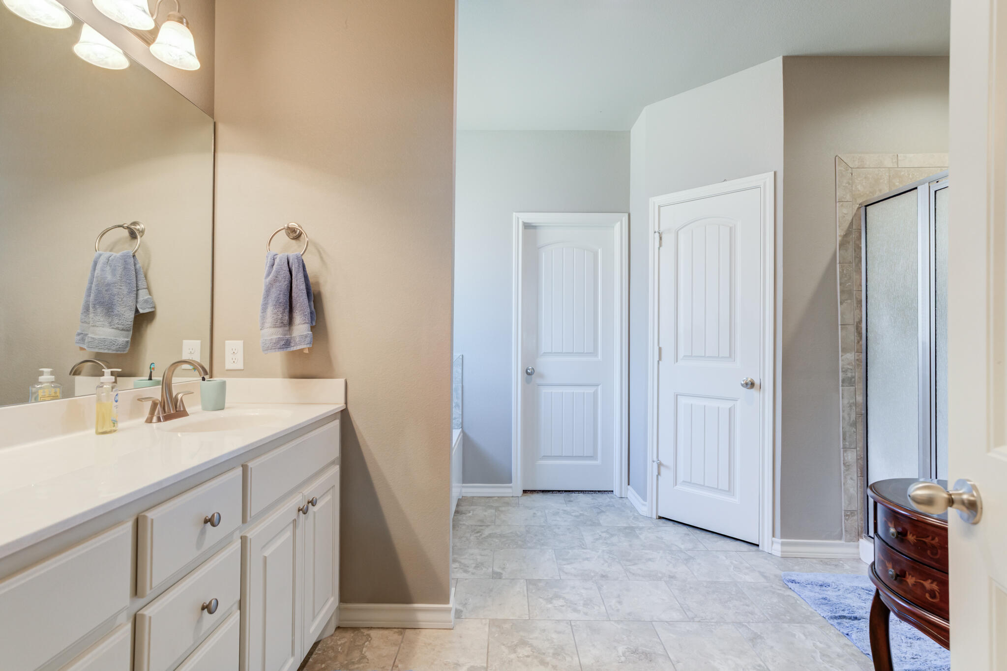 5219 Kemper Street Lubbock, TX 79416 - Photo 23 of 38 a spacious bathroom with a double vanity sink and a mirror