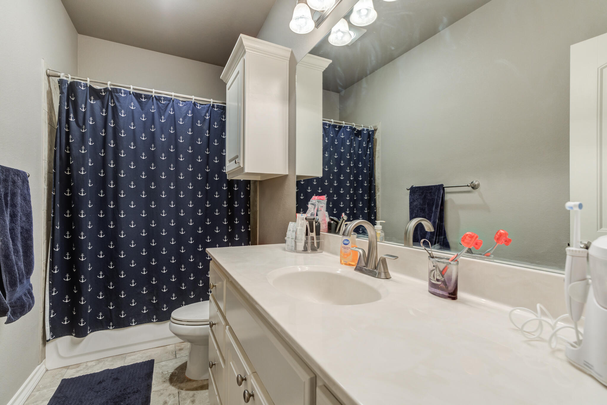 5219 Kemper Street Lubbock, TX 79416 - Photo 32 of 38 a bathroom with a sink toilet vanity and shower