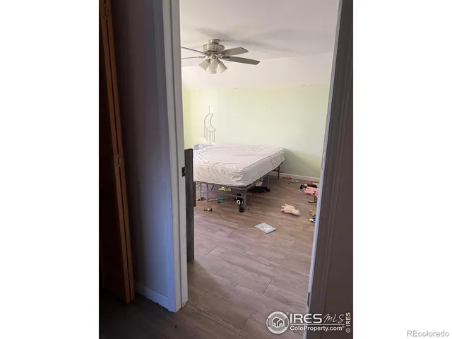 a bedroom with a bed and a wooden floor
