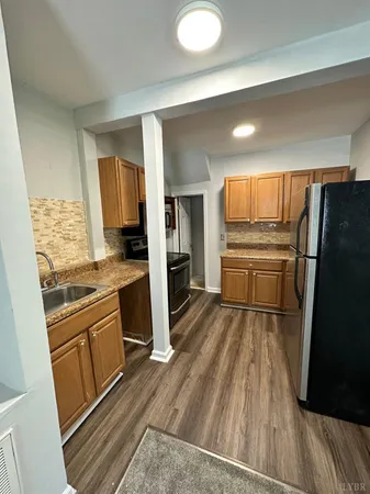a kitchen with a refrigerator and a stove top oven