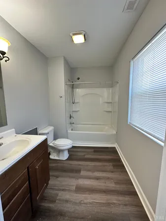 a bathroom with a sink a toilet and a window