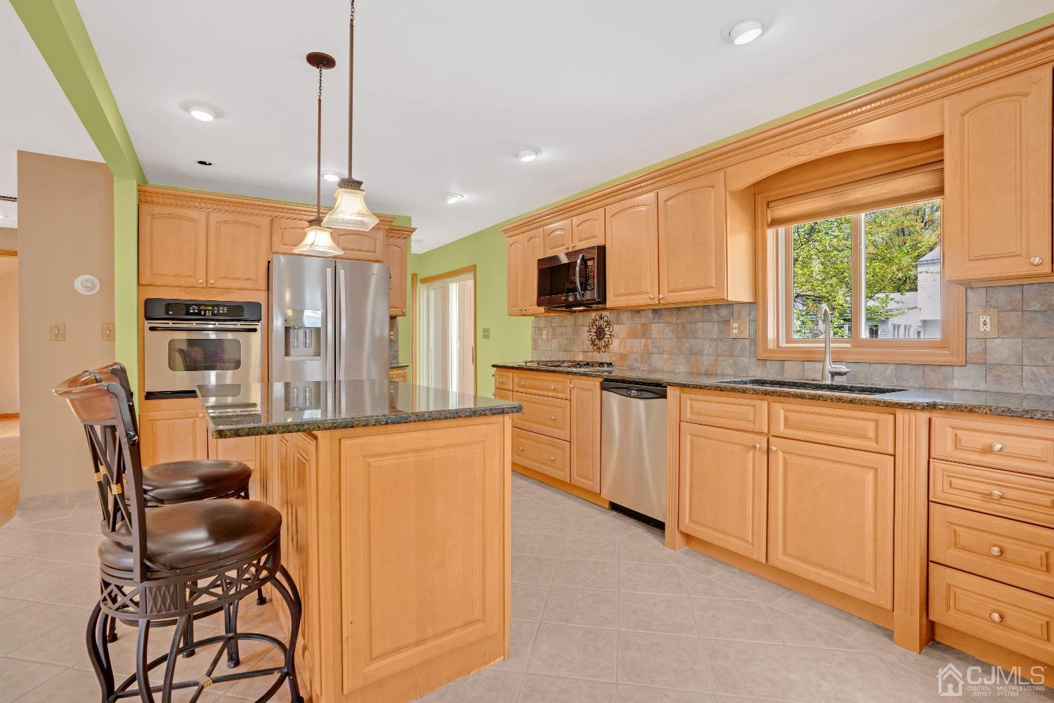 44 Terry Avenue Edison, NJ 08820 - Photo 13 of 47 a kitchen with stainless steel appliances granite countertop a sink a stove a refrigerator cabinets and a dining table with wooden floor