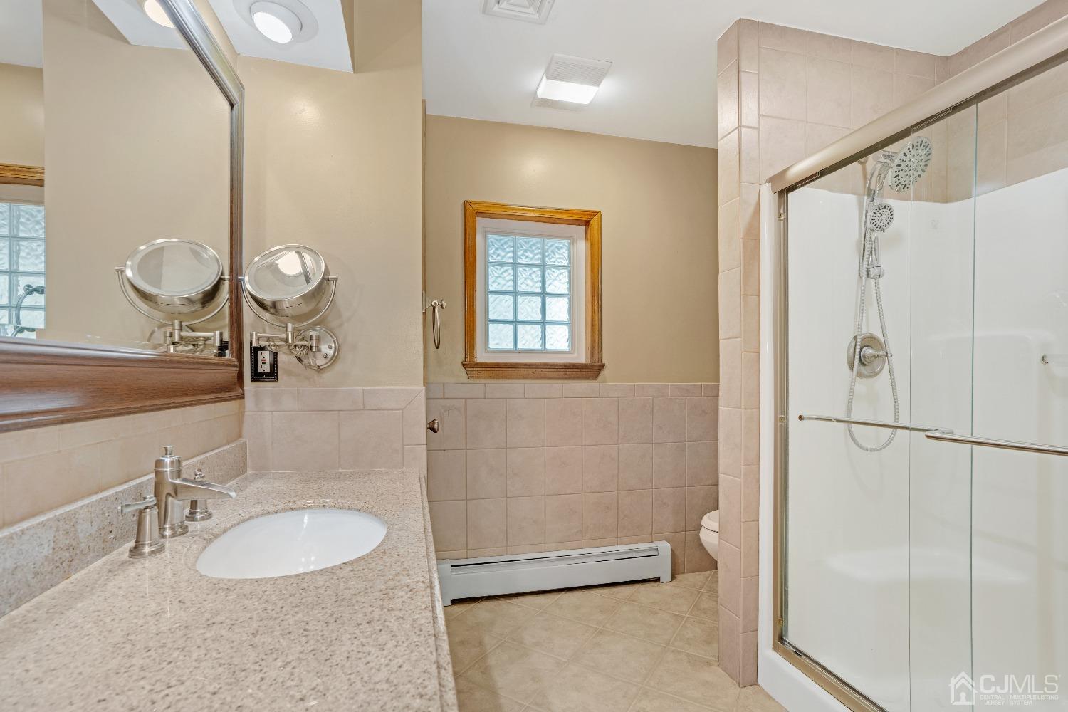 44 Terry Avenue Edison, NJ 08820 - Photo 23 of 47 a bathroom with a double vanity sink a mirror and a shower