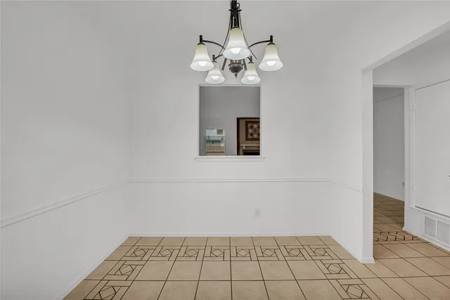 a view of a room with wooden floor and chandelier