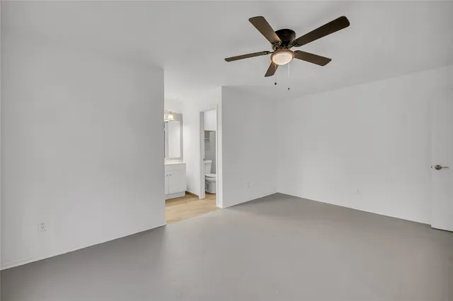 an empty room with closet and ceiling fan
