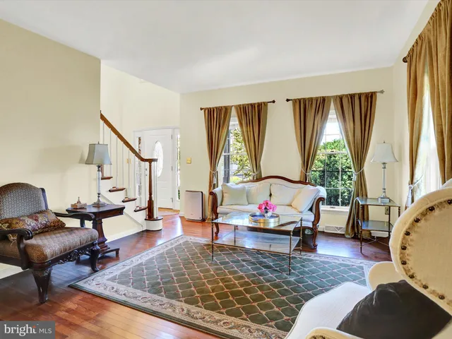 a dining room with furniture a chandelier and wooden floor