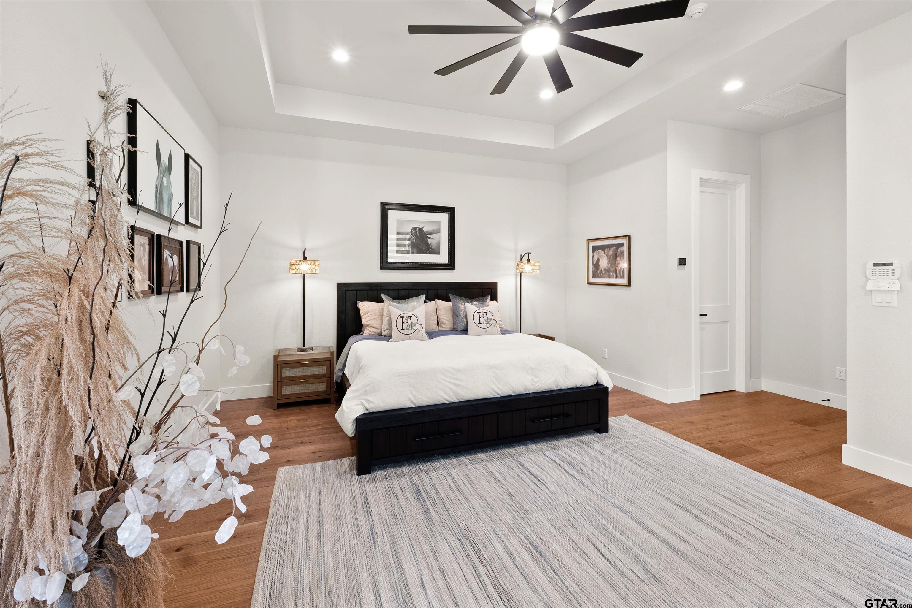 2895 Stewart Way Tyler, TX 75709 - Photo 17 of 44 a bedroom with a large bed and a chandelier