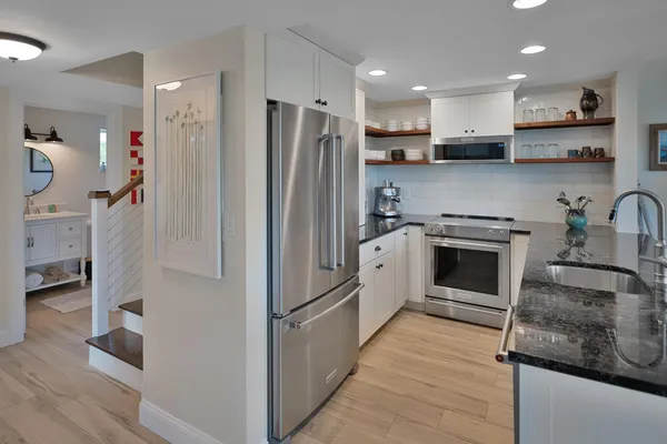 a kitchen with stainless steel appliances granite countertop a refrigerator sink and stove