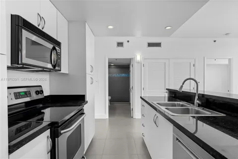 a kitchen with granite countertop stainless steel appliances a stove sink and microwave