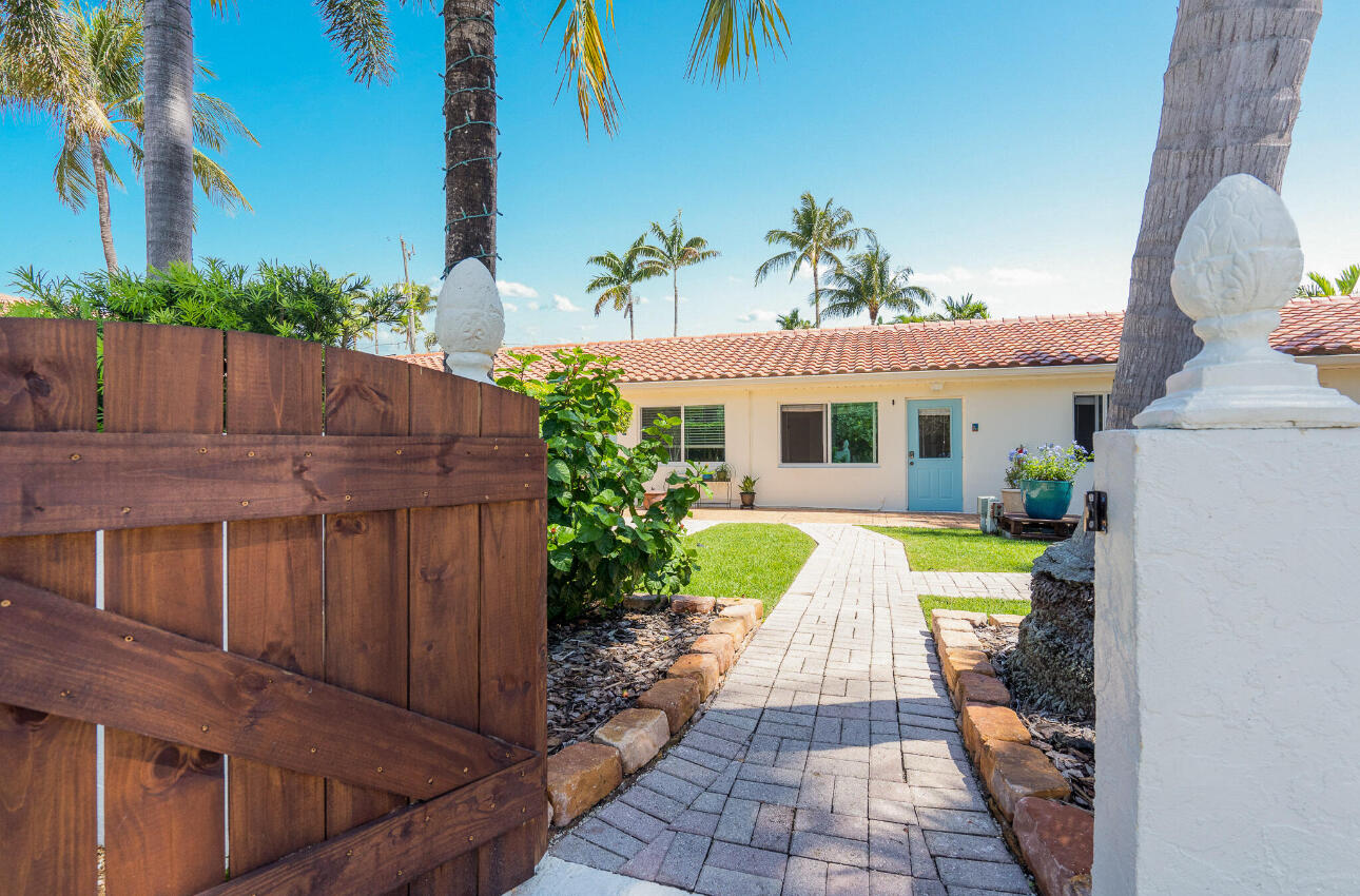 11 Tropical Drive, Unit 4 Ocean Ridge, FL 33435 - Photo 2 of 7 a front view of a house with a yard and potted plants