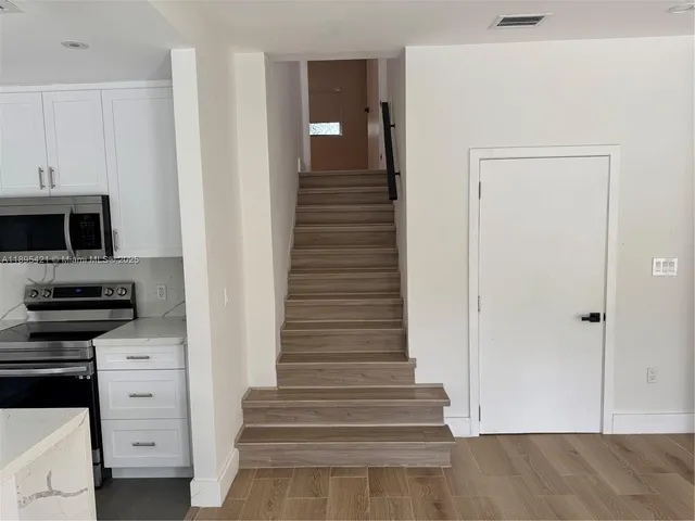 a view of a hallway with kitchen and entryway