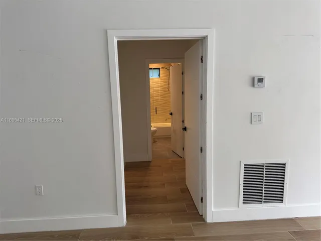 a view of a big room with wooden floor and windows