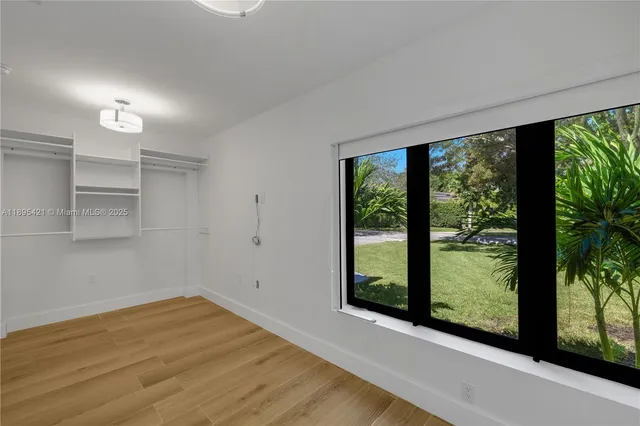 a view of a room with wooden floor and windows