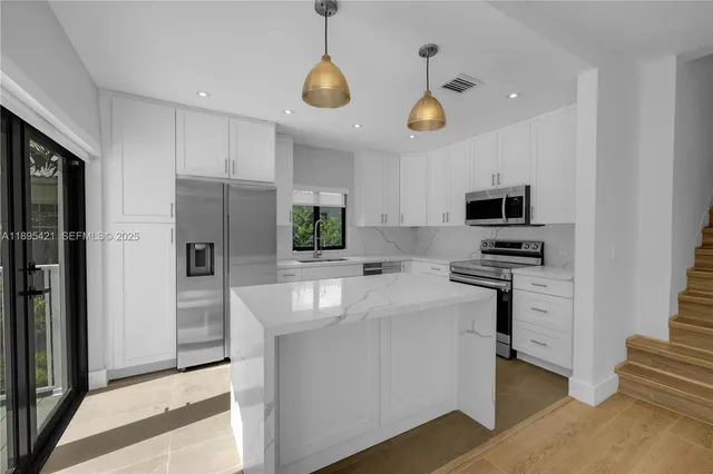 a kitchen with stainless steel appliances a stove a refrigerator and a sink