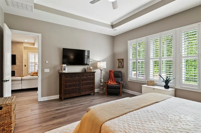 a bedroom with a bed and large windows