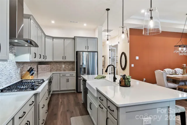 a kitchen with refrigerator a stove a sink dishwasher with a dining table and chairs