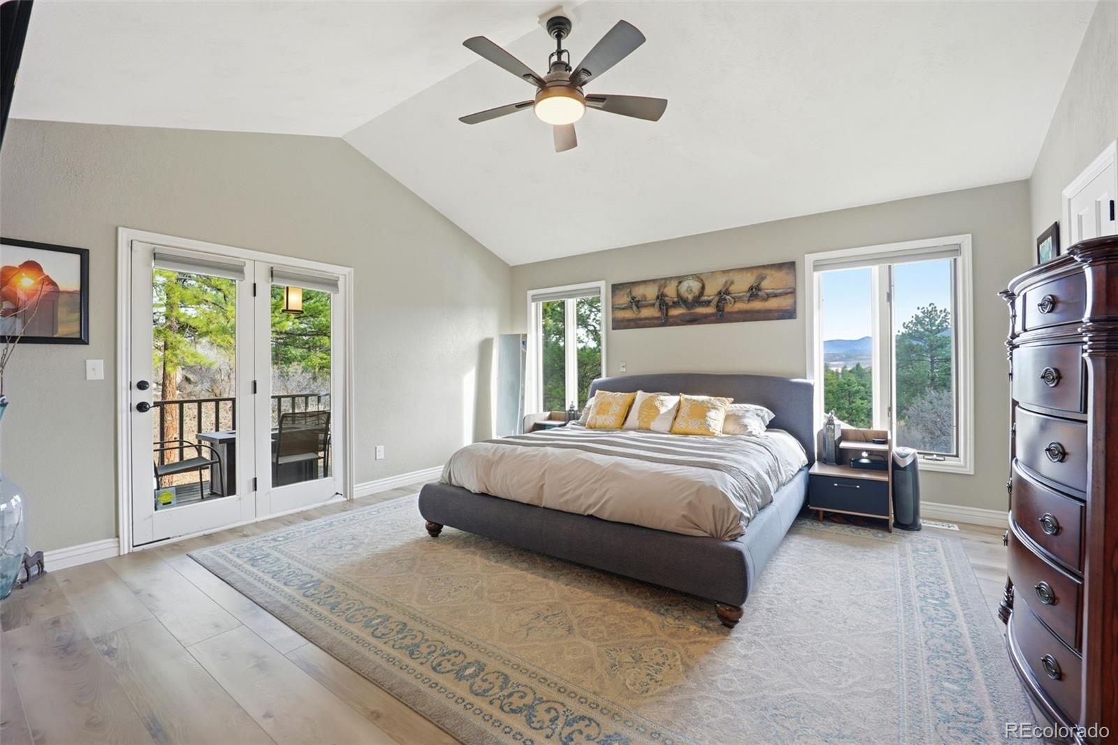 5000 South Perry Park Road Sedalia, CO 80135 - Photo 16 of 50 a spacious bedroom with a large bed and a chandelier fan