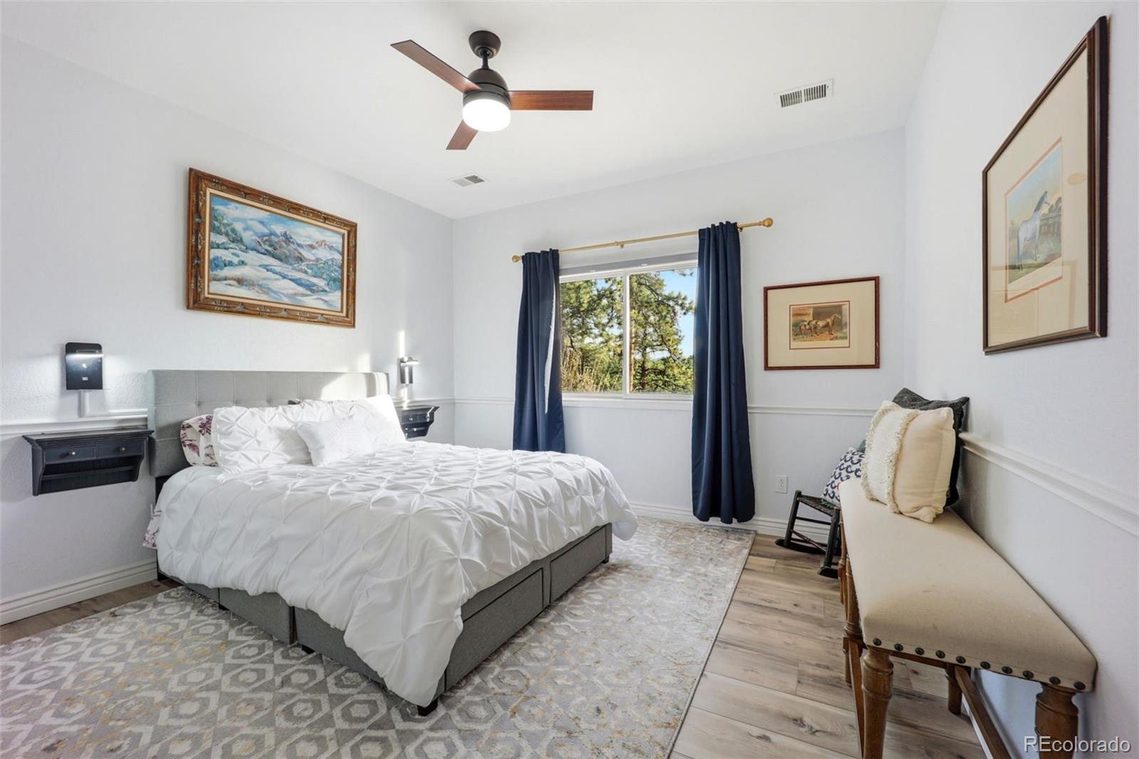 5000 South Perry Park Road Sedalia, CO 80135 - Photo 25 of 50 a bedroom with a bed and a chandelier