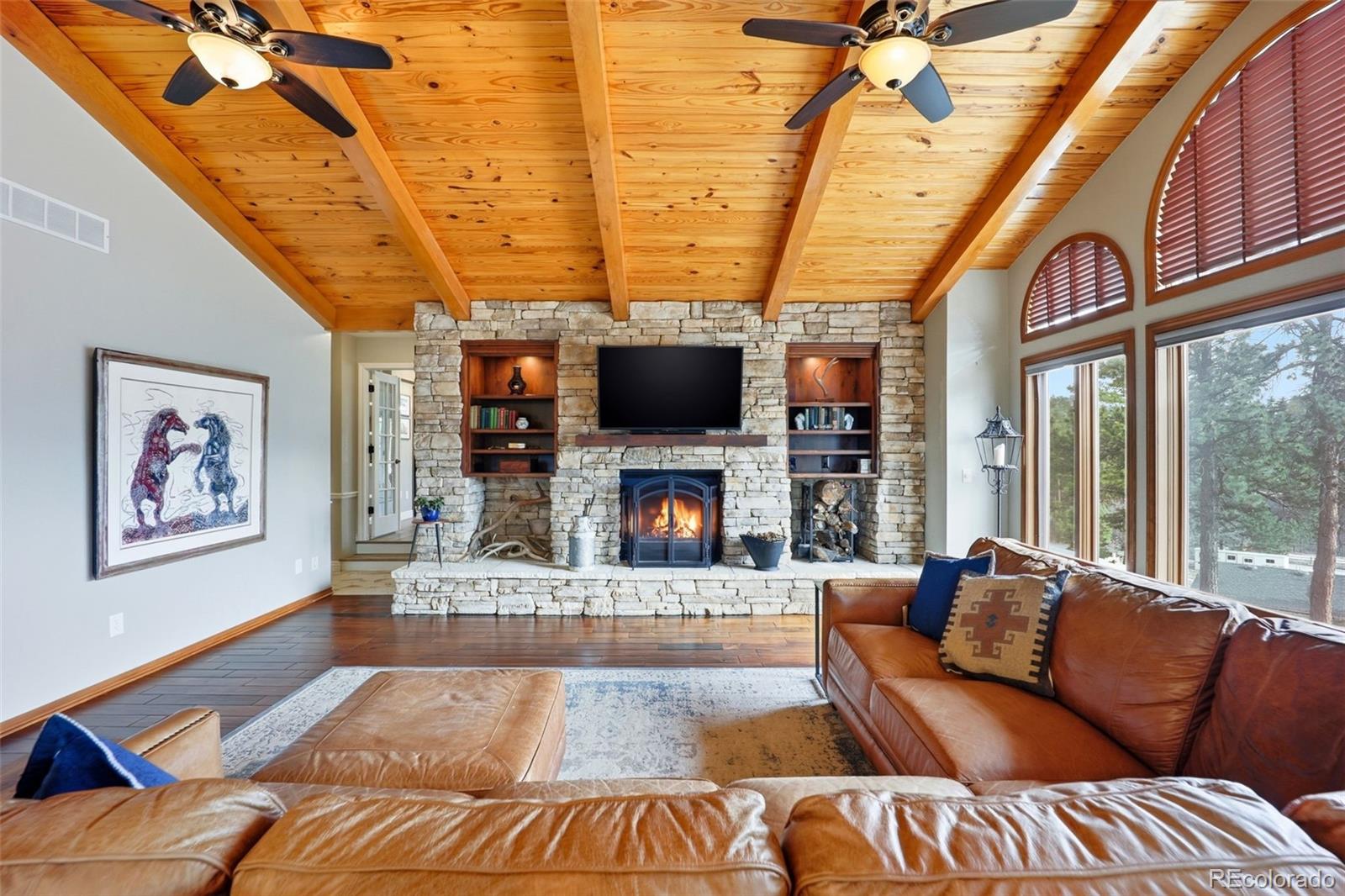 5000 South Perry Park Road Sedalia, CO 80135 - Photo 10 of 50 a living room with furniture a flat screen tv and a fireplace