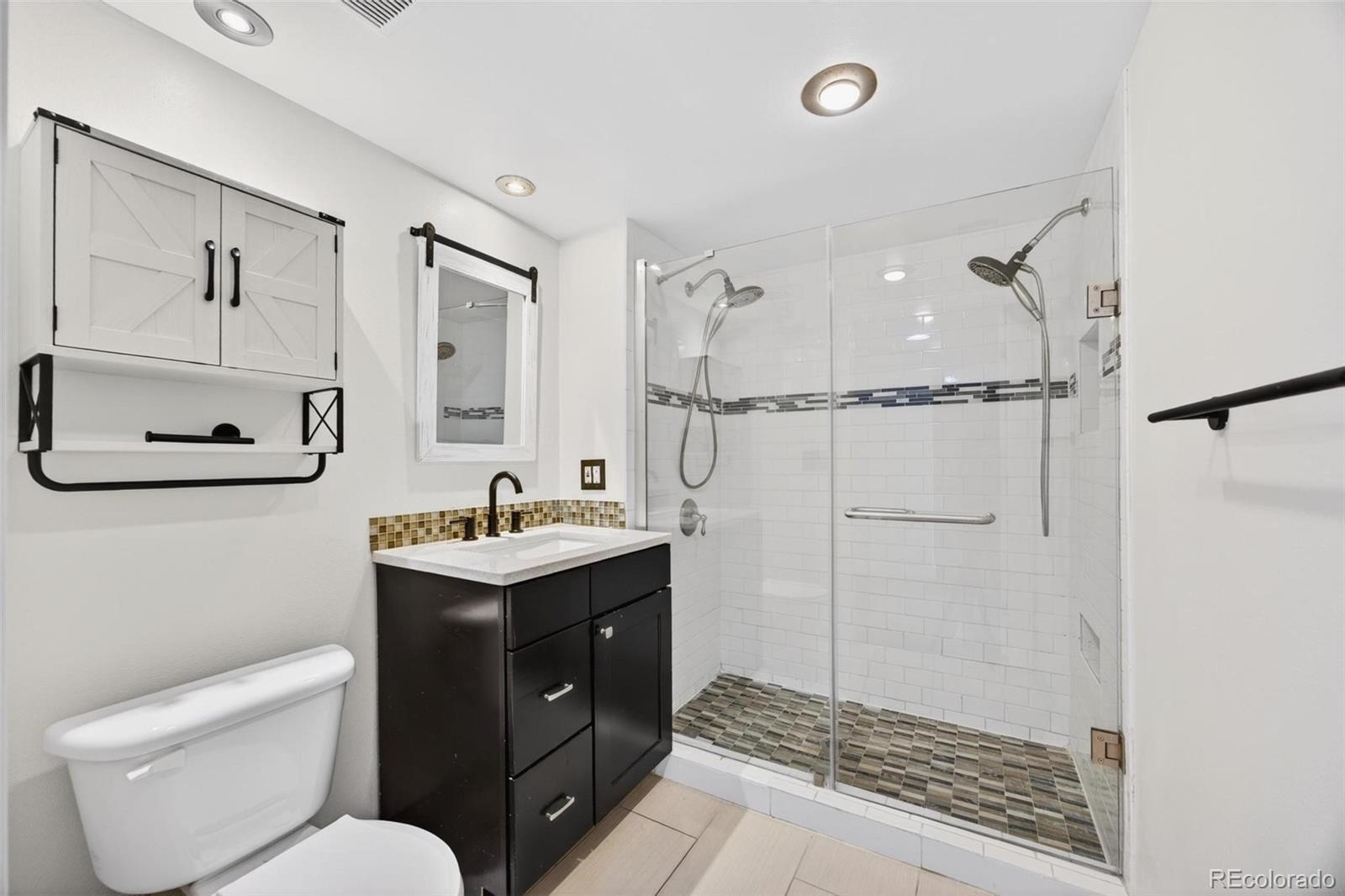 1150 Inca Street, Unit 46 Denver, CO 80204 - Photo 14 of 45 a bathroom with a toilet sink vanity and mirror