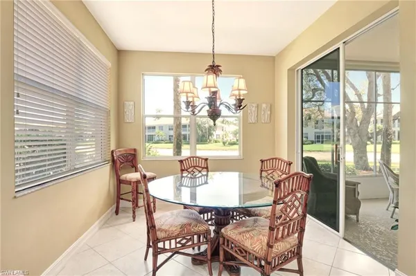 a dining room with furniture a chandelier and wooden floor