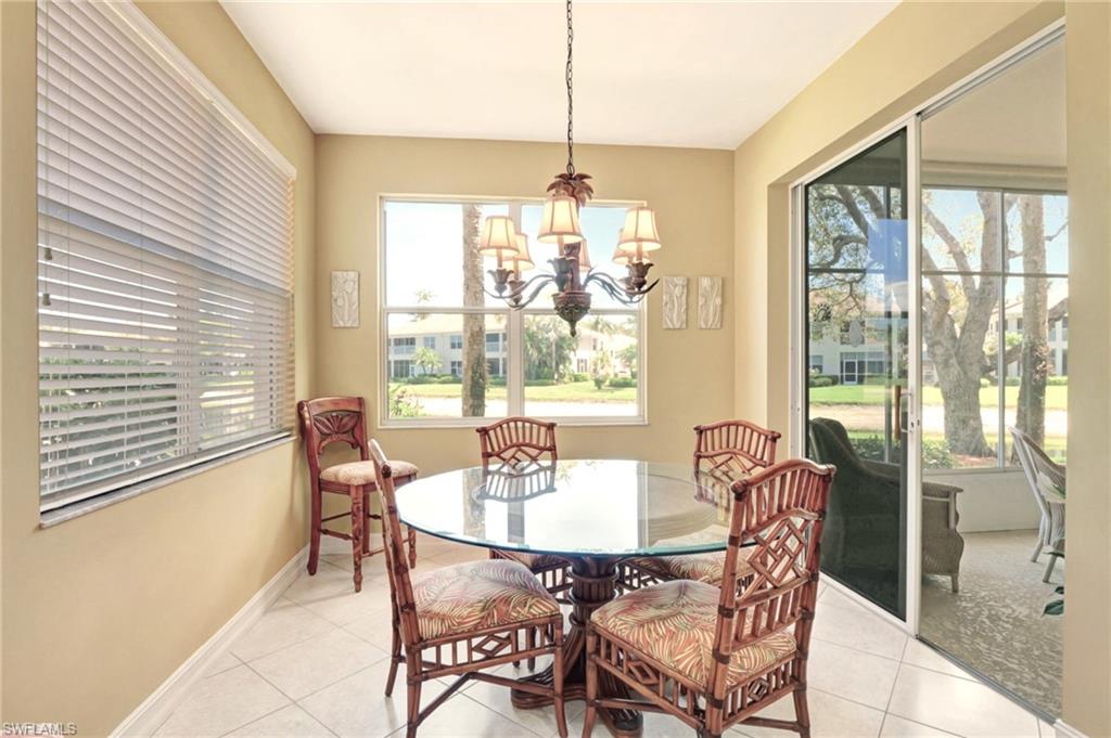 784 Carrick Bend Circle, Unit 101 Naples, FL 34110 - Photo 13 of 34 a dining room with furniture a chandelier and wooden floor