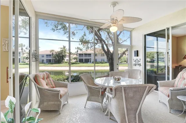 a dining room with furniture a chandelier and a floor to ceiling window