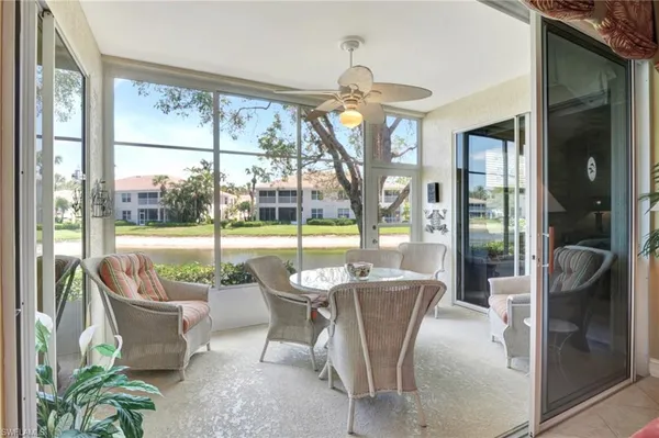 a dining room with furniture water view and a floor to ceiling window