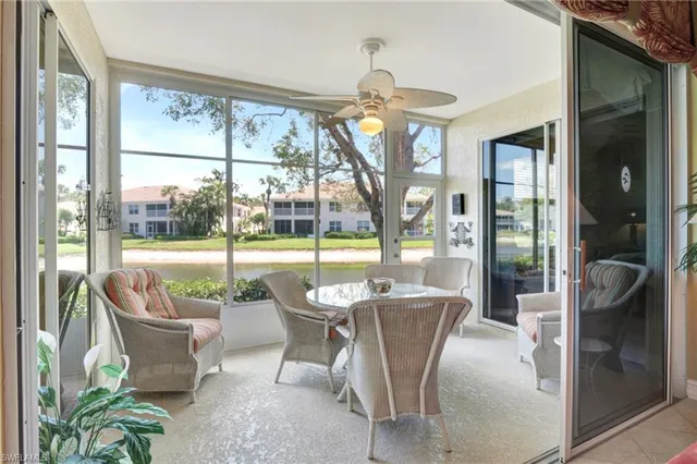 a dining room with furniture water view and a floor to ceiling window