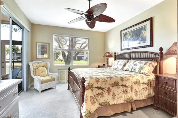 a bedroom with a bed couches and a large window