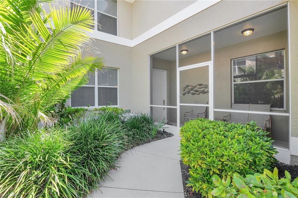 784 Carrick Bend Circle, Unit 101 Naples, FL 34110 - Photo 2 of 34 front view of a house with a garden