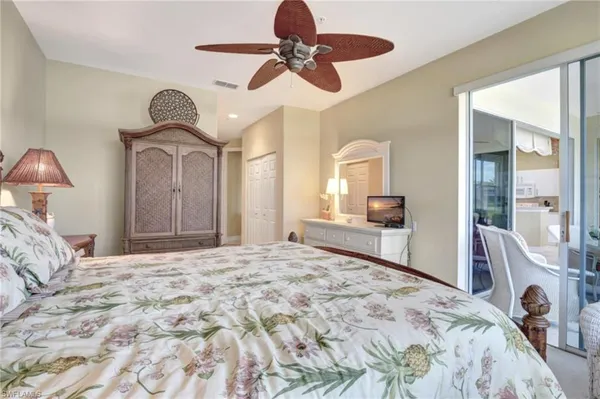 a bedroom with a bed a chandelier and dresser