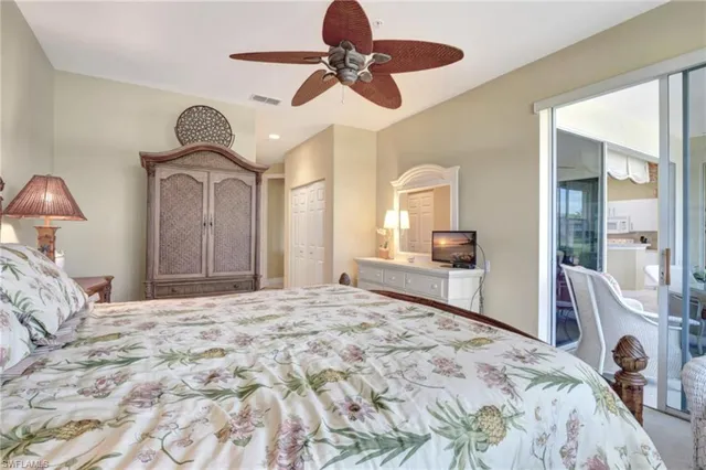a bedroom with a bed a chandelier and dresser