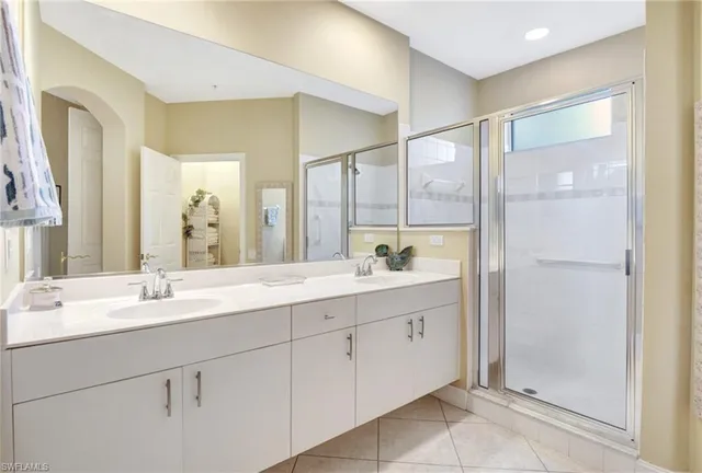 a bathroom with a double vanity sink mirror and shower