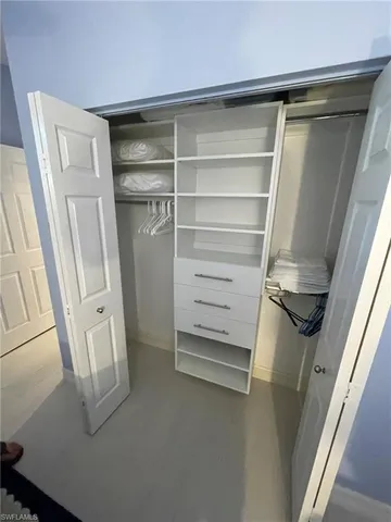 a view of walk in closet with empty racks