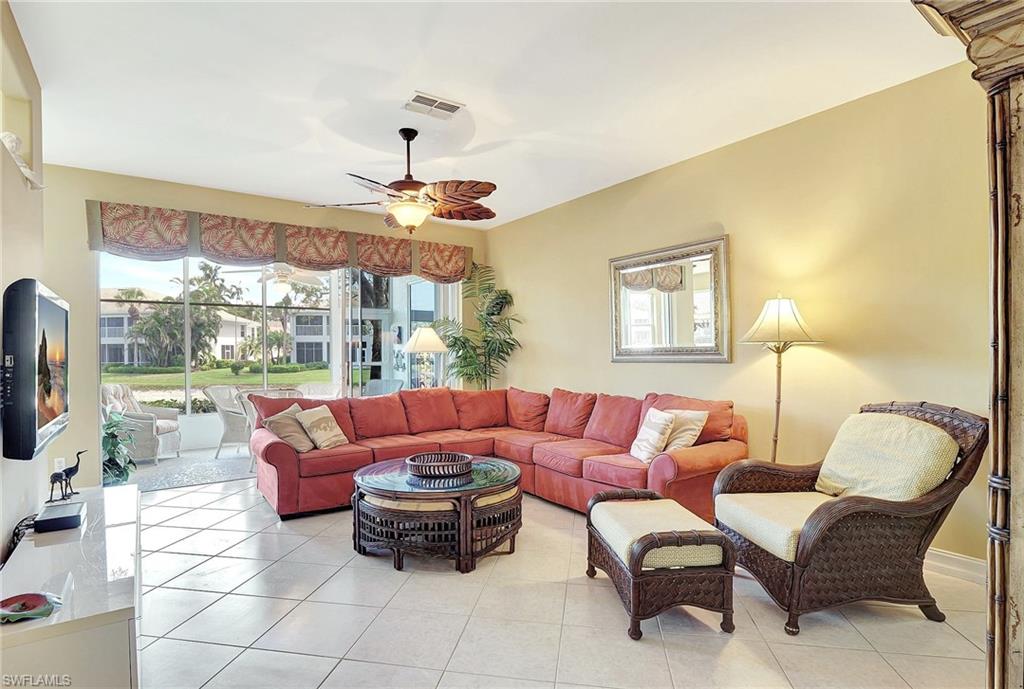 784 Carrick Bend Circle, Unit 101 Naples, FL 34110 - Photo 3 of 34 a living room with furniture and a floor to ceiling window