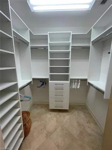 a view of walk in closet with empty racks