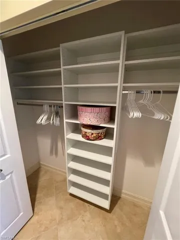 a view of walk in closet with empty racks