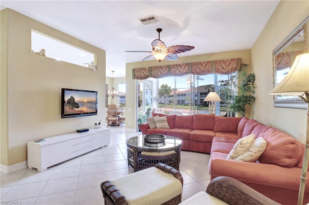 784 Carrick Bend Circle, Unit 101 Naples, FL 34110 - Photo 4 of 34 a living room with furniture and a flat screen tv