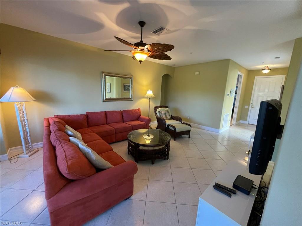 784 Carrick Bend Circle, Unit 101 Naples, FL 34110 - Photo 6 of 34 a living room with furniture and a chandelier