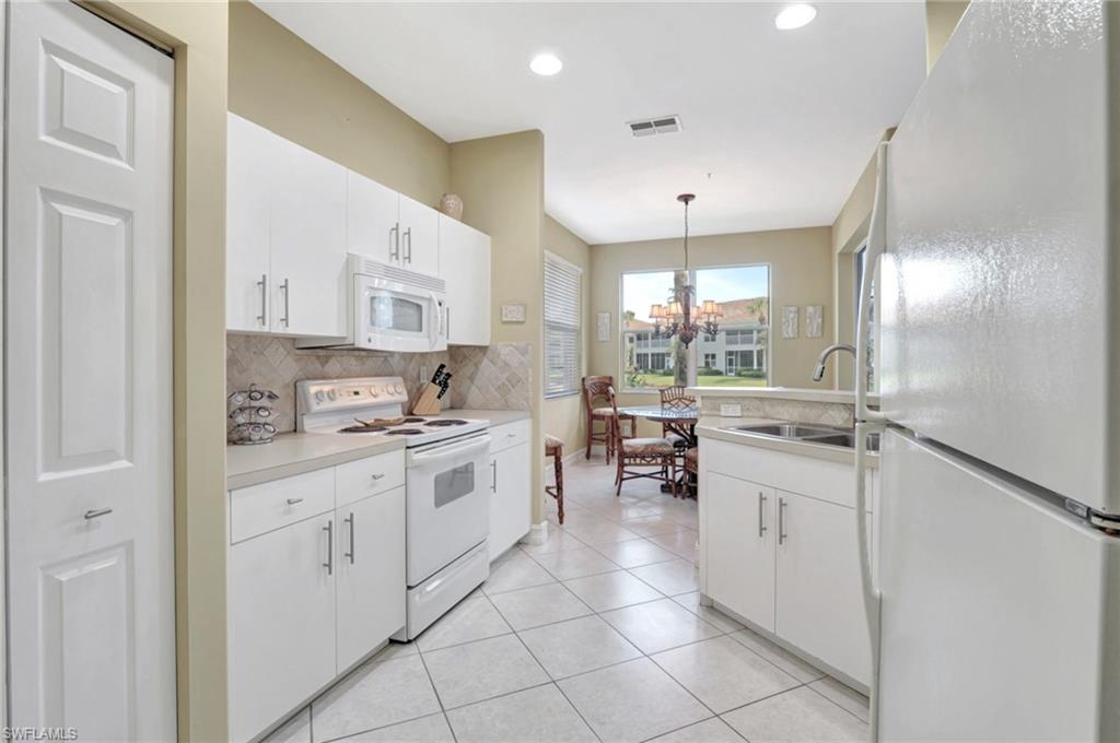 784 Carrick Bend Circle, Unit 101 Naples, FL 34110 - Photo 8 of 34 a kitchen with stainless steel appliances a sink stove and cabinets