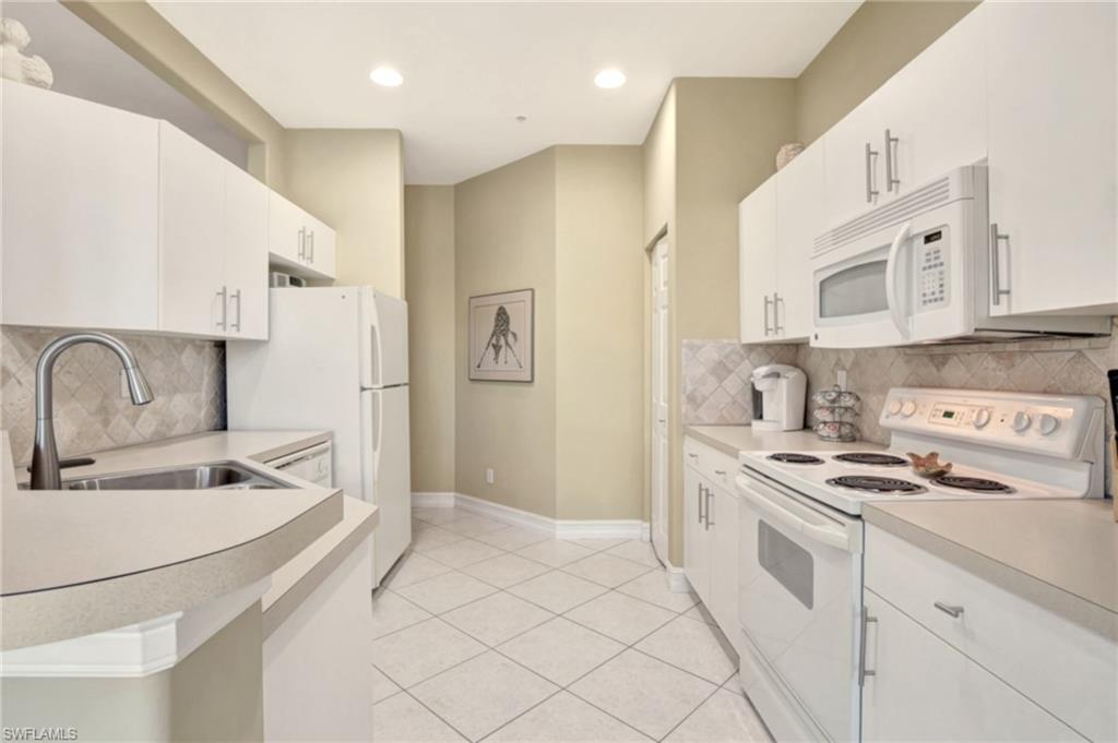784 Carrick Bend Circle, Unit 101 Naples, FL 34110 - Photo 10 of 34 a kitchen with stainless steel appliances granite countertop a sink and cabinets