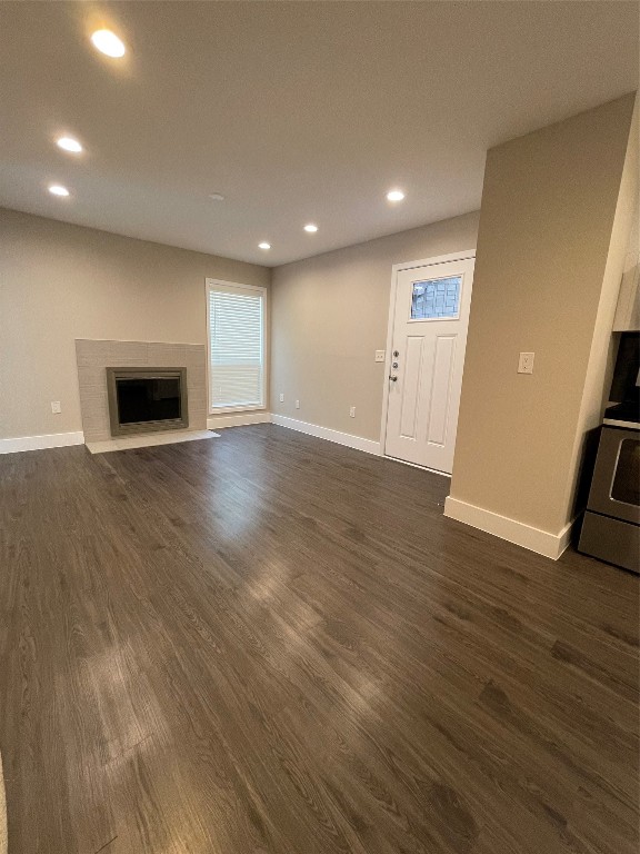 935 La Posada Drive, Unit 145 Austin, TX 78752 - Photo 2 of 23 an empty room with wooden floor and fireplace
