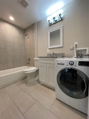 a bathroom with a sink a washer and dryer