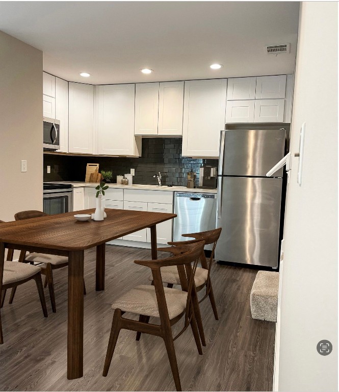 935 La Posada Drive, Unit 145 Austin, TX 78752 - Photo 7 of 23 a kitchen with a table chairs refrigerator and microwave