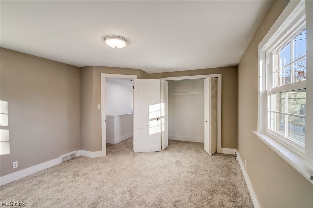 3660 Harvey Road Cleveland, OH 44118 - Photo 16 of 32 Unfurnished bedroom with multiple windows, a closet, and light colored carpet