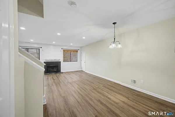 wooden floor in an empty room with a kitchen