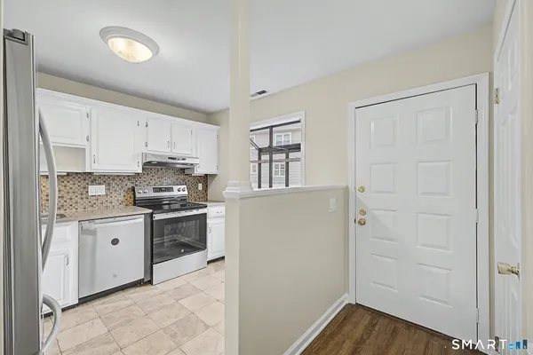 a kitchen with stainless steel appliances granite countertop a stove and a refrigerator