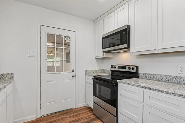 a kitchen with stainless steel appliances granite countertop a stove microwave and sink